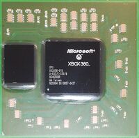 An image of a 90 nanometer graphics processing unit from a Microsoft Xbox 360. The die is in the center of the green square, and the eDRAM is located to the left of it. The die has dark greenish low Tg underfill under it, indicating that it is defective.