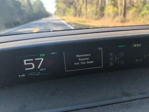 Dashboard with screen showing "Maintenance Required Visit Your Dealer"